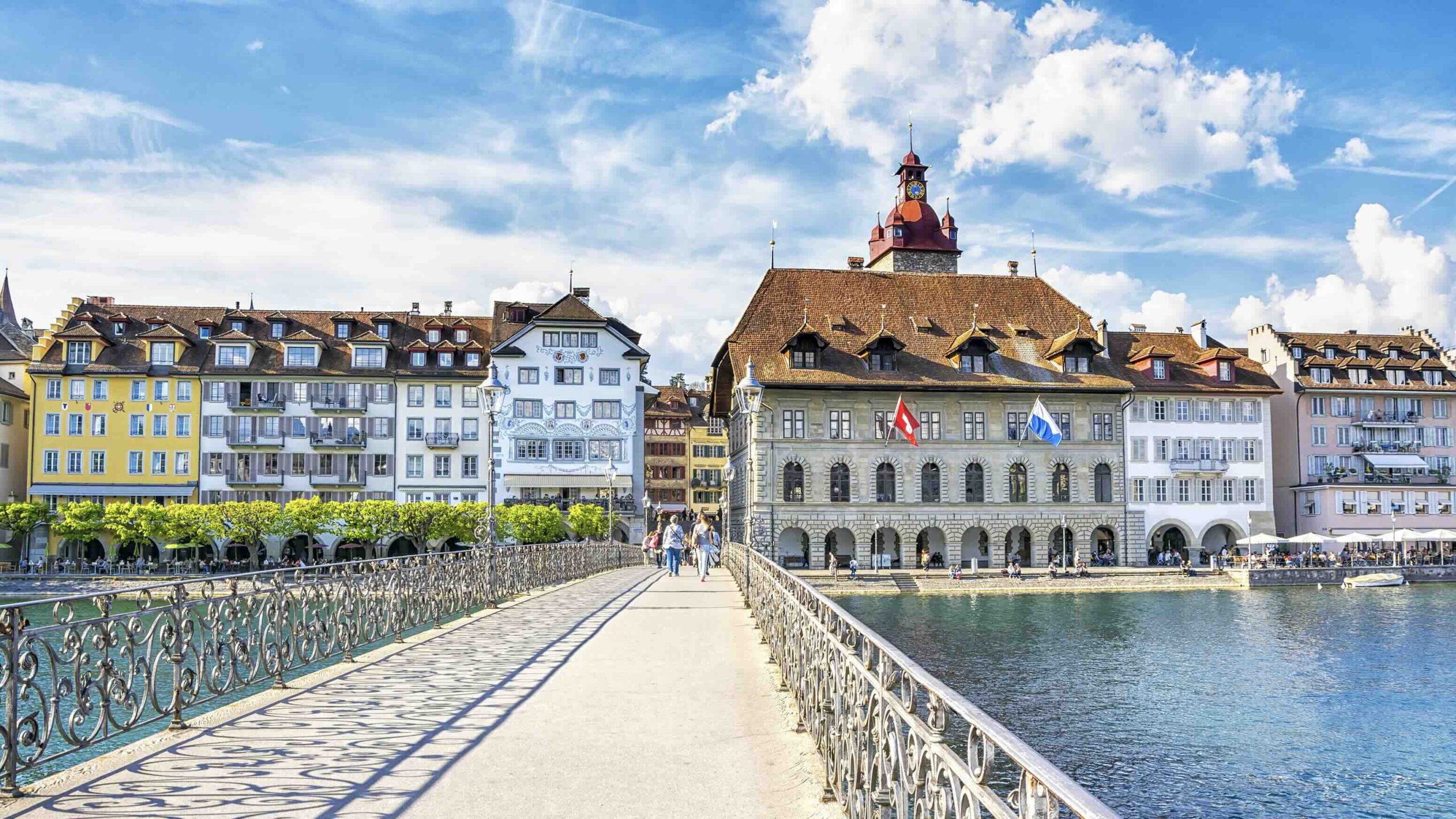 View on the beautiful picturesque historic buildings with cafe and restaurants from Rathaussteg Bridge over Reuss River in Old Town Lucerne.